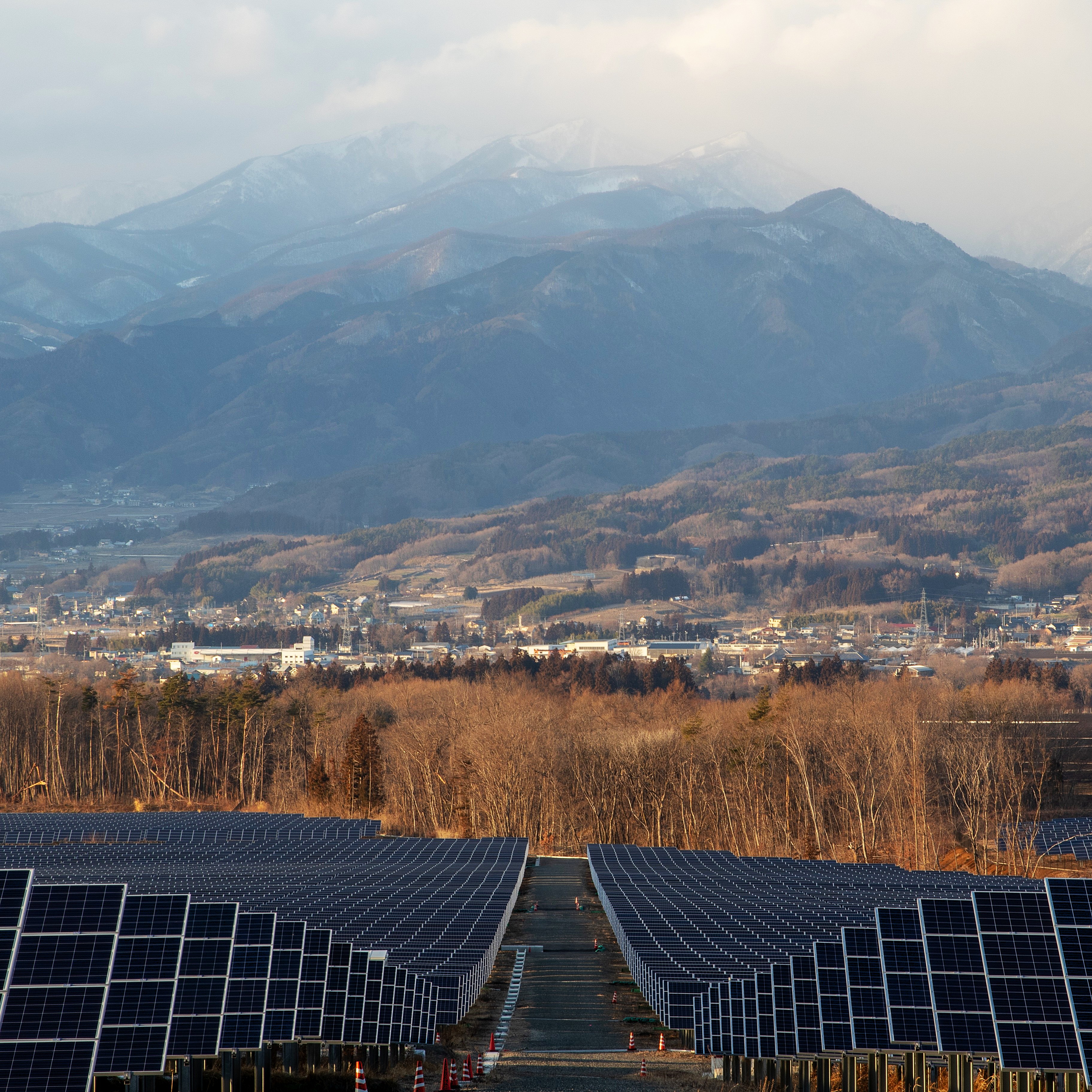 Solar installation beside a rural village and mountains