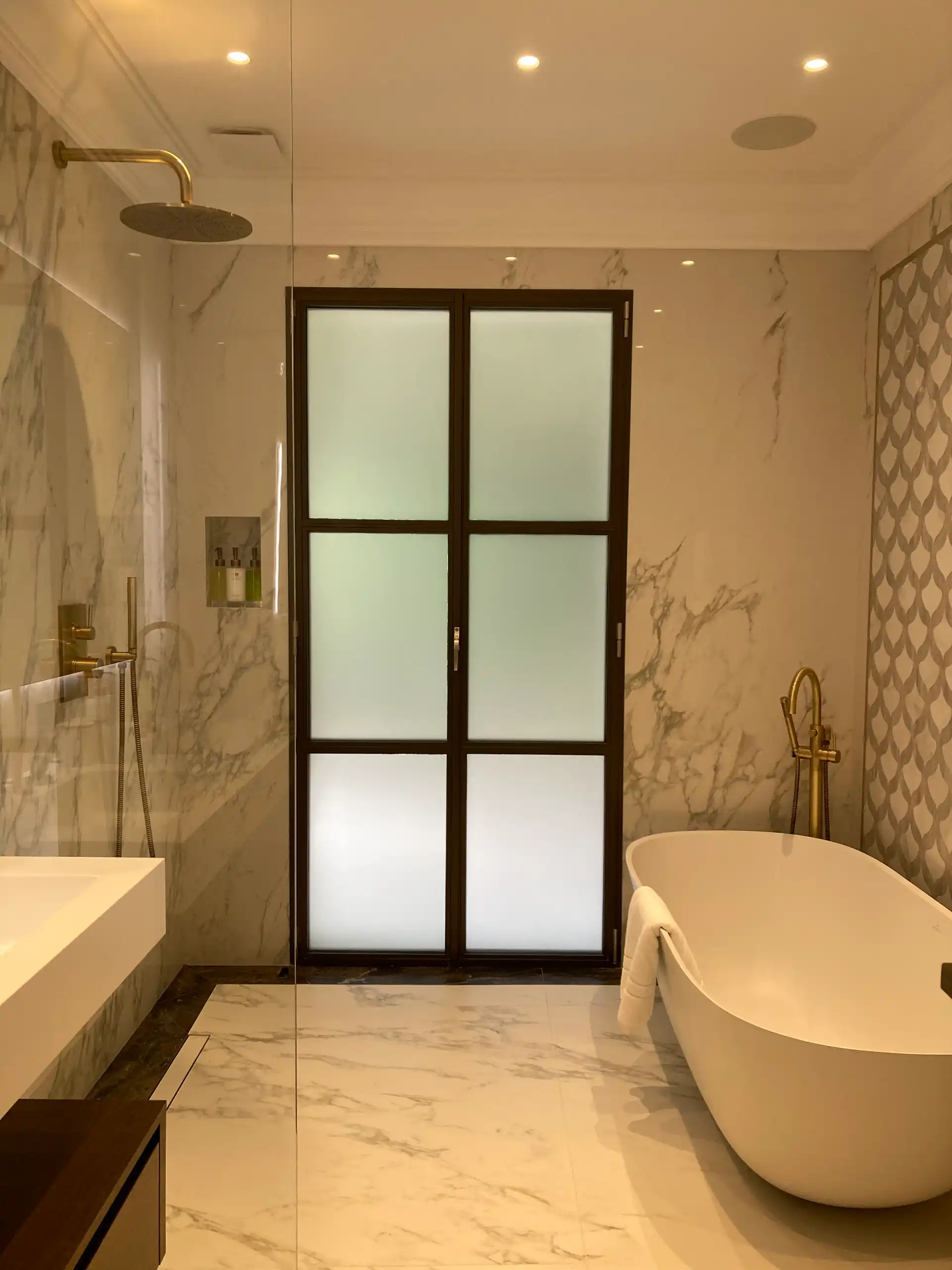 Porte vitrée dépolie dans une salle de bain de villa