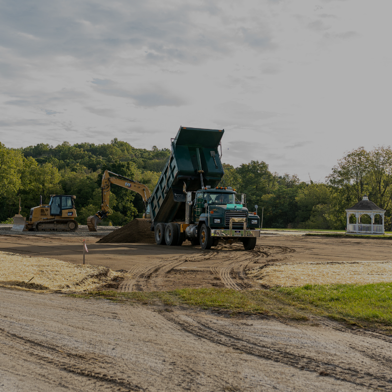 Wantage Excavating tri-axle dump truck delivering topsoil to a construction site in Lafayette, NJ for grading and site preparation work.