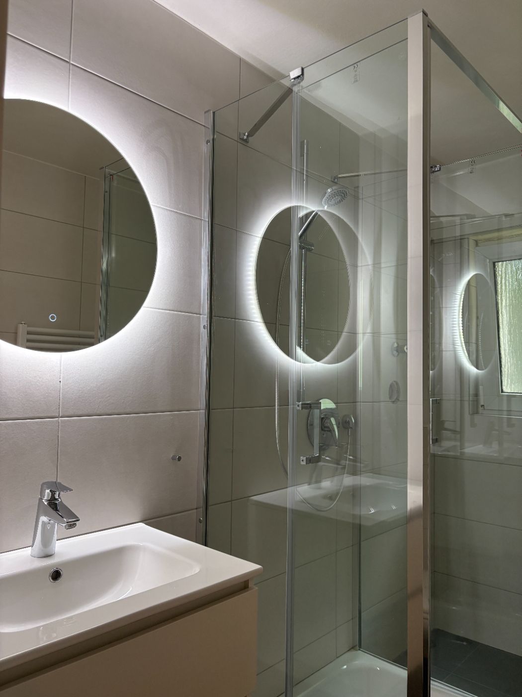 Bad mit Dusche und beleuchtetem Spiegel