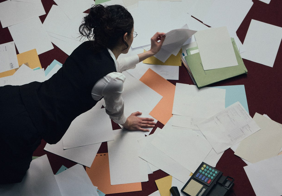An adviser sorting through printed records and folders during a discovery review