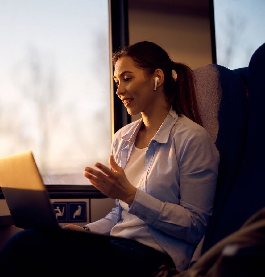 A business owner working on her laptop while travelling at dusk