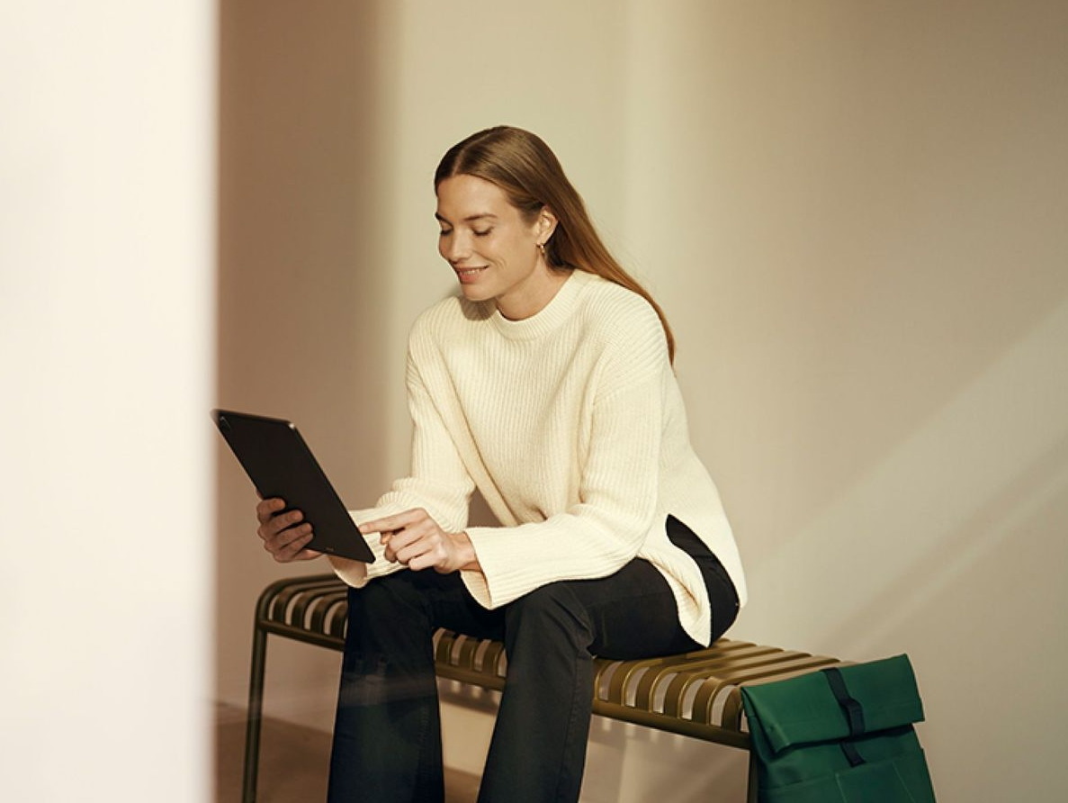 A business owner reviewing her accounts on a tablet in a quiet office