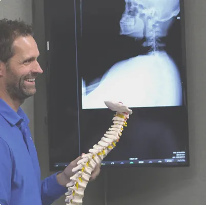 Cervical spine X-ray displayed on an exam room monitor
