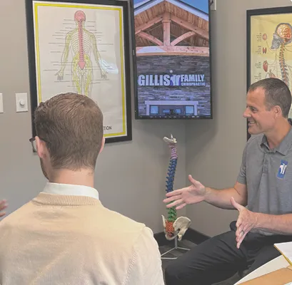 Patient reviewing a spine and nervous system chart with staff