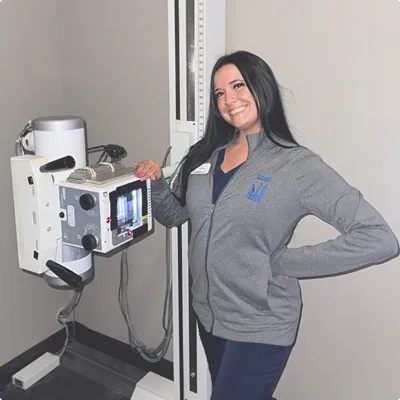 Gillis Family Chiropractic staff member next to the digital X-ray machine