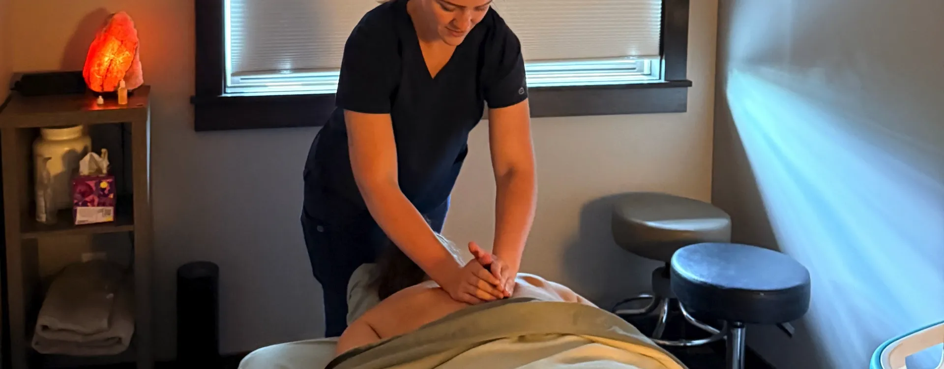 Massage therapist performing a back massage