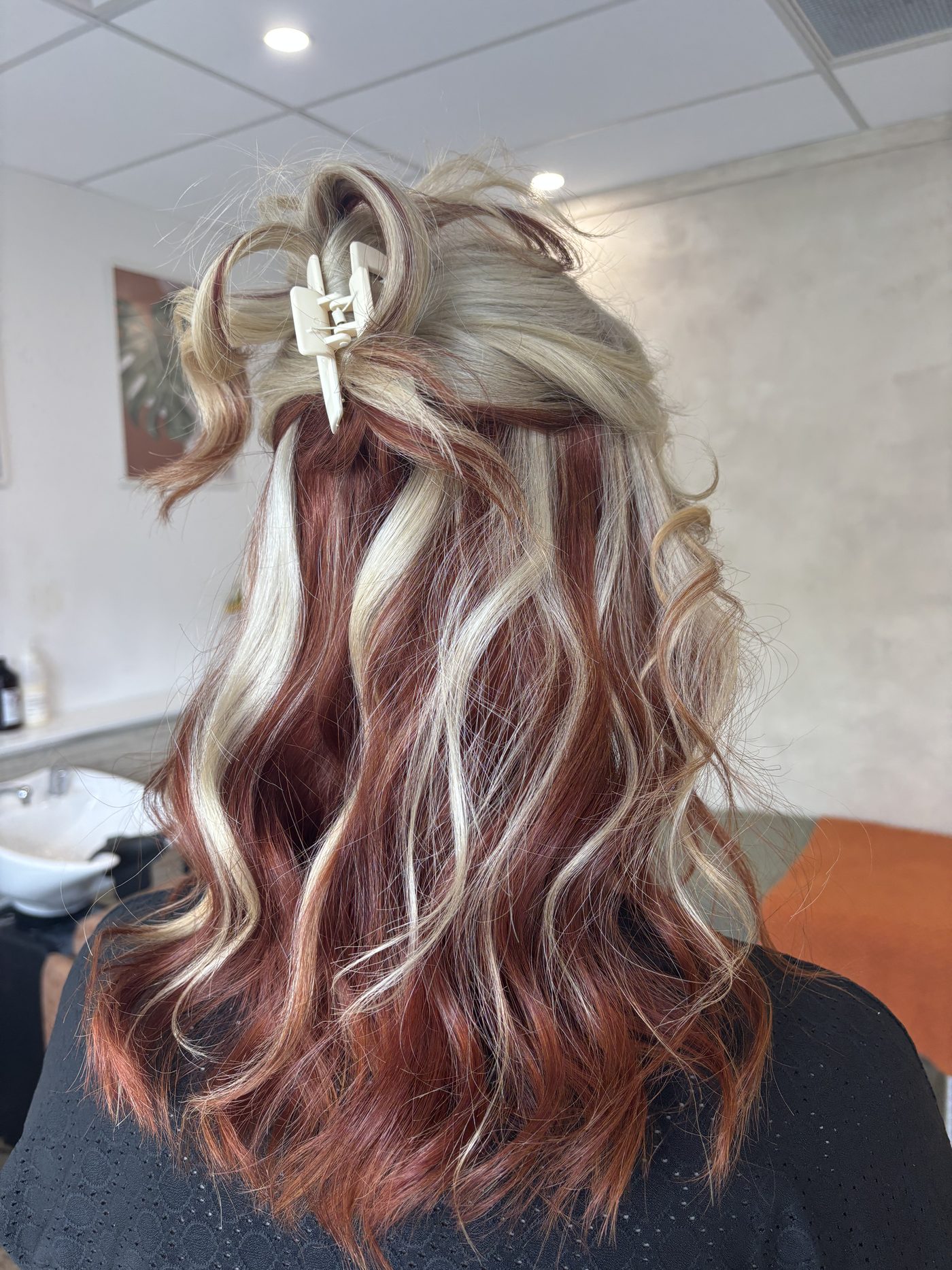 Blonde and copper highlights blended through long waves at Purabelle in Nerang