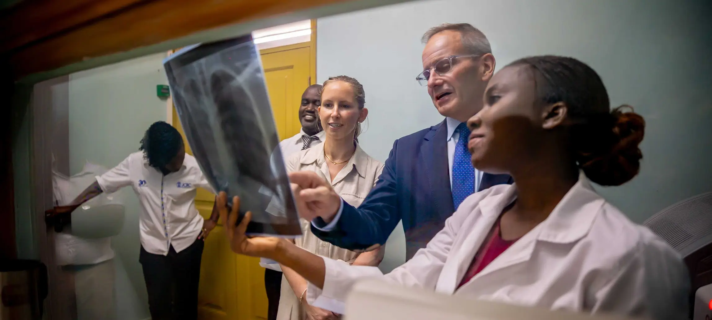 Group of medical professionals reviewing a chest X-ray in a clinical setting.