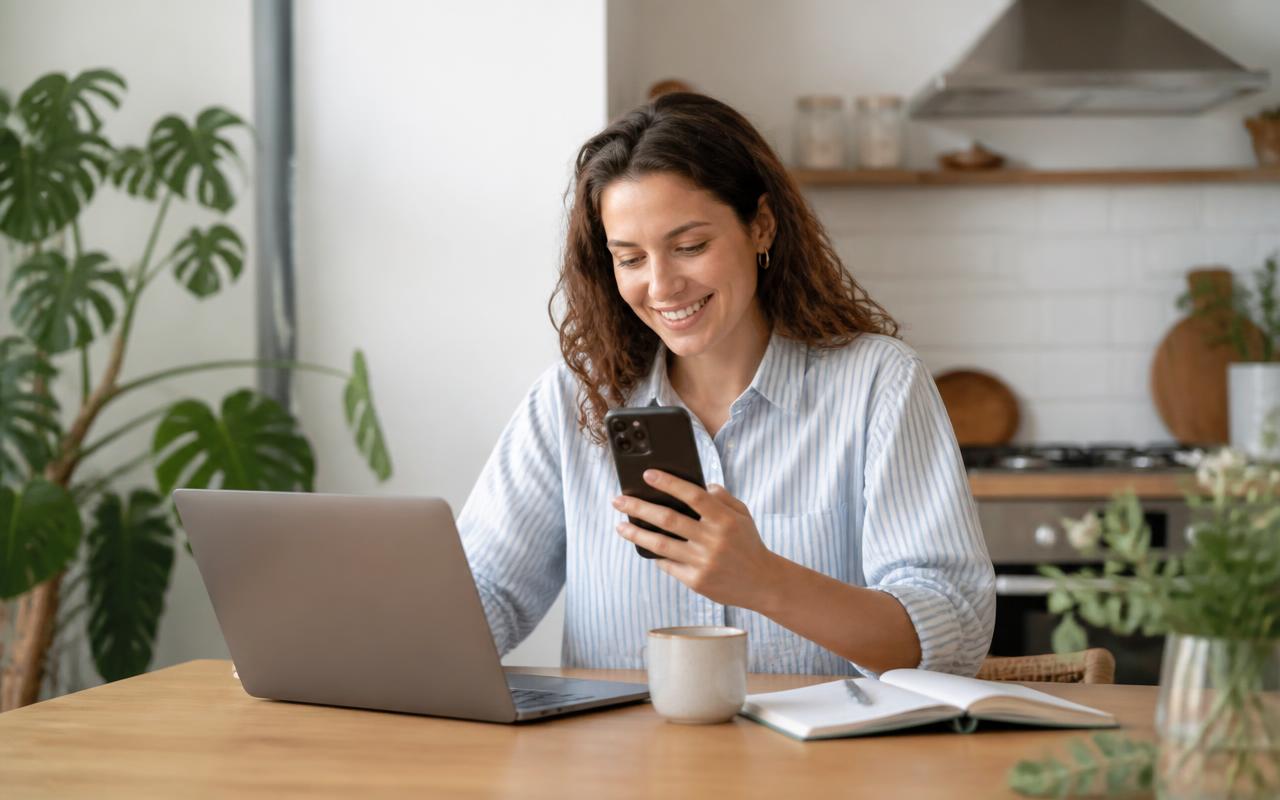 Cardholder smiling while using a mobile phone on a city street
