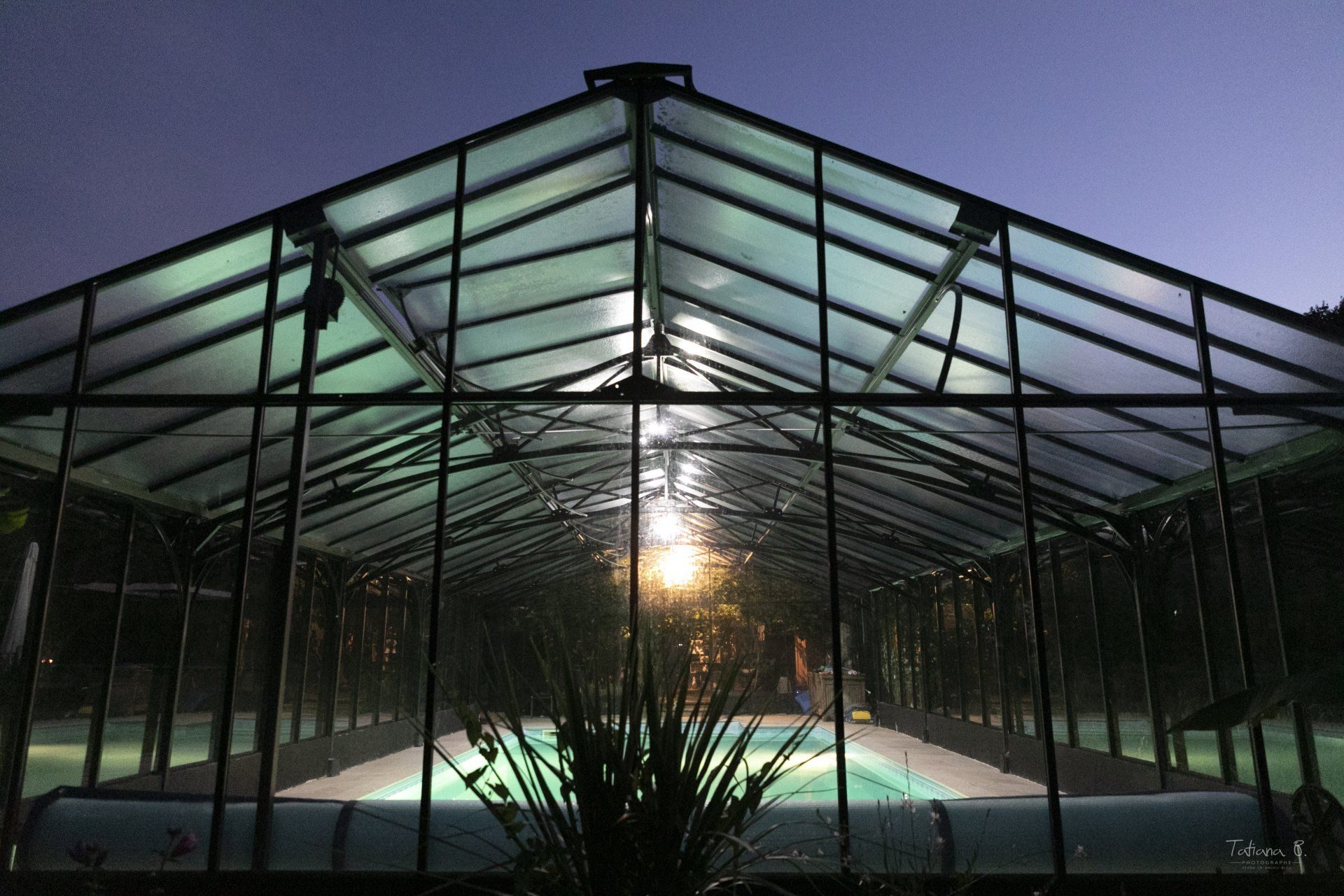 Piscine sous verrière au crépuscule