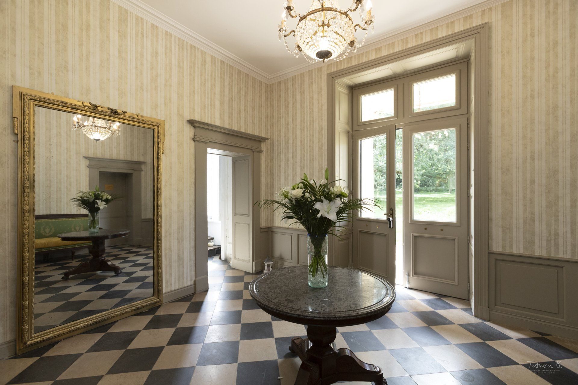 Le hall d'entrée du château, sol en damier et miroir doré
