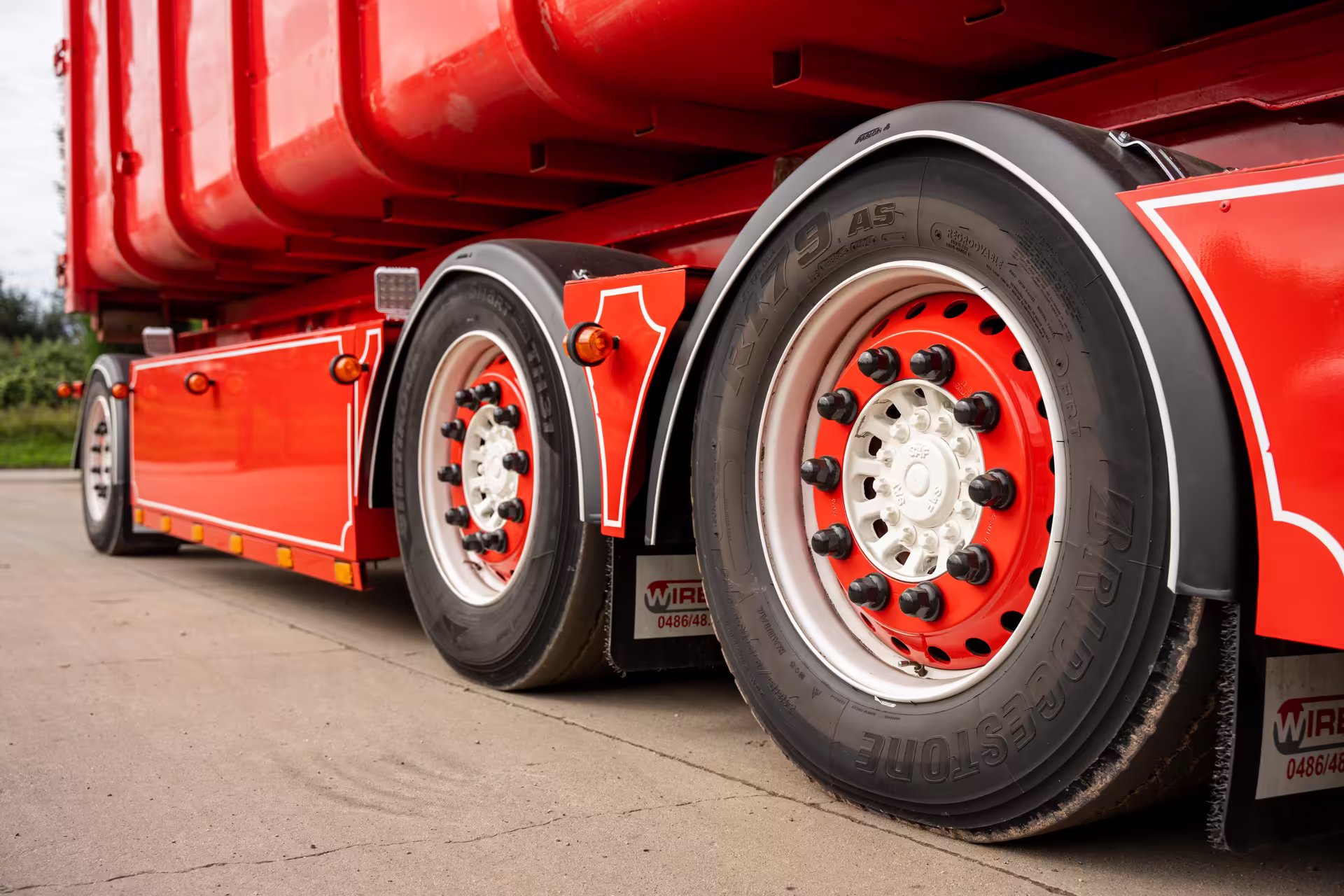 Detail van de wielen van een rode Bob Peeters-containerwagen