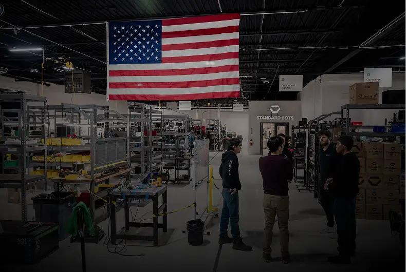Standard Bots factory floor with an American flag hanging from the ceiling