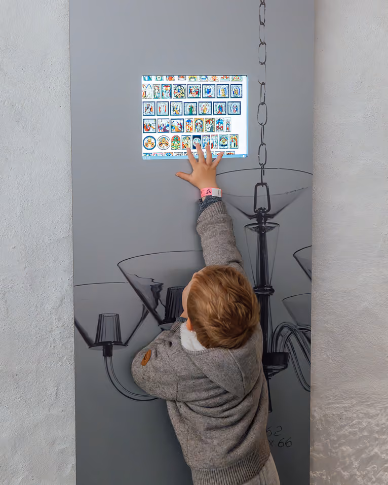 Enfant pointant une planche d’images accrochée au mur d’un musée