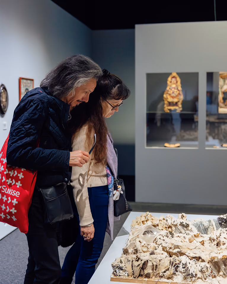Deux visiteuses observant une maquette dans une salle d’exposition