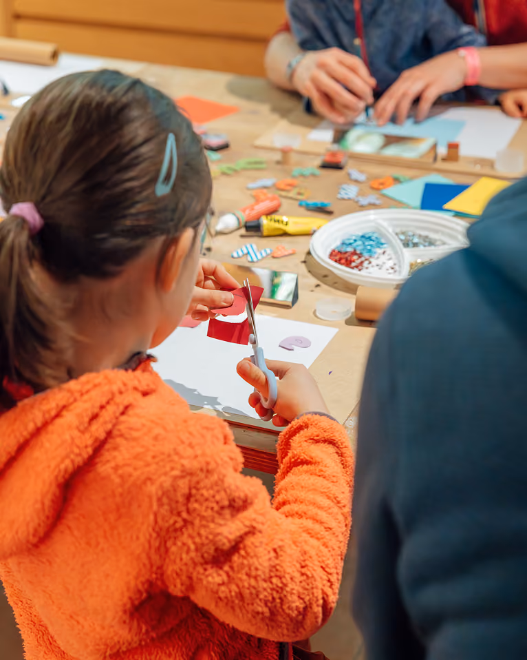 Enfant découpant du papier coloré lors d’un atelier créatif