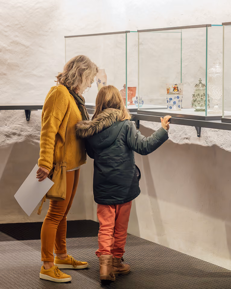 Adulte et enfant regardant des objets présentés en vitrine