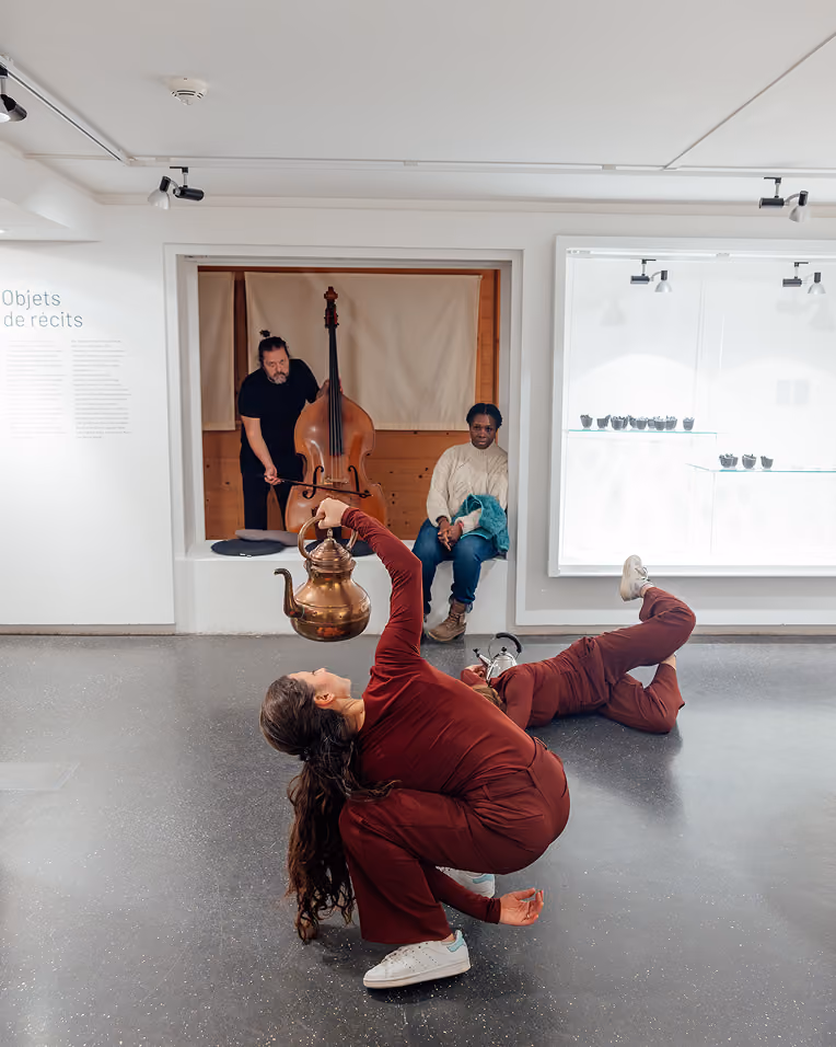 Performance de danse dans une salle de musée, avec un contrebassiste en arrière-plan