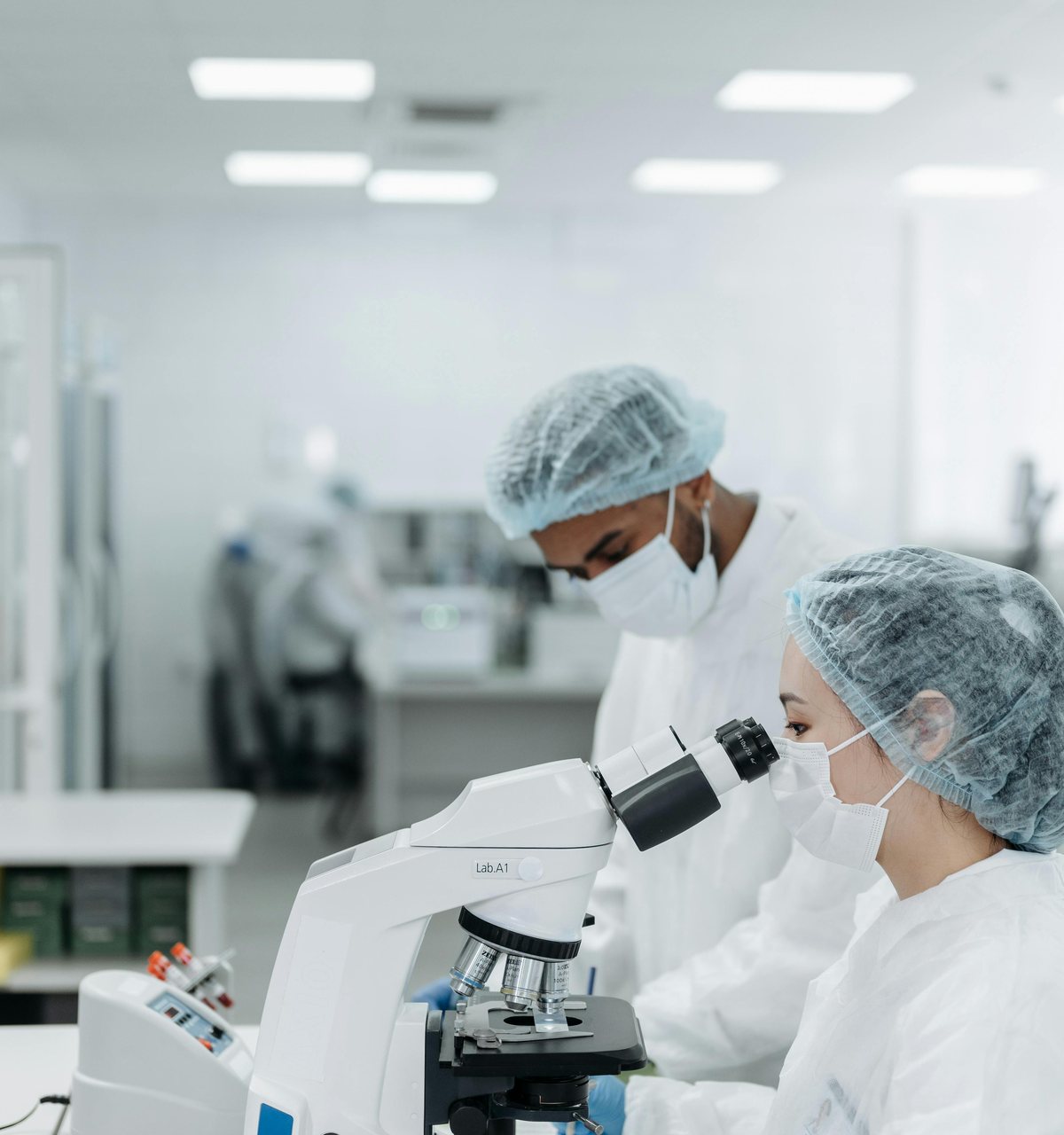 Laboratory technicians running tests at a microscope