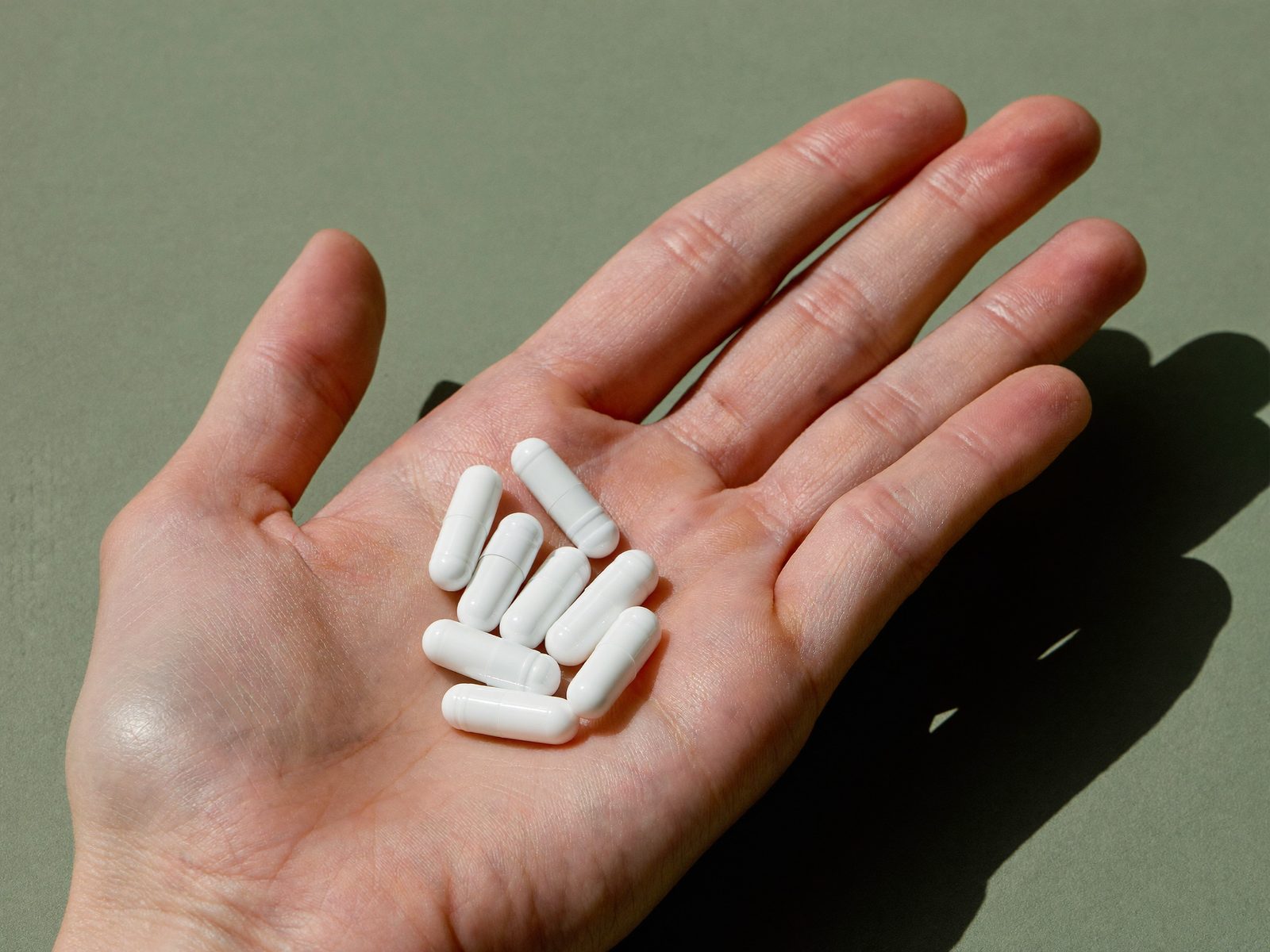 White size 00 capsules in an open palm