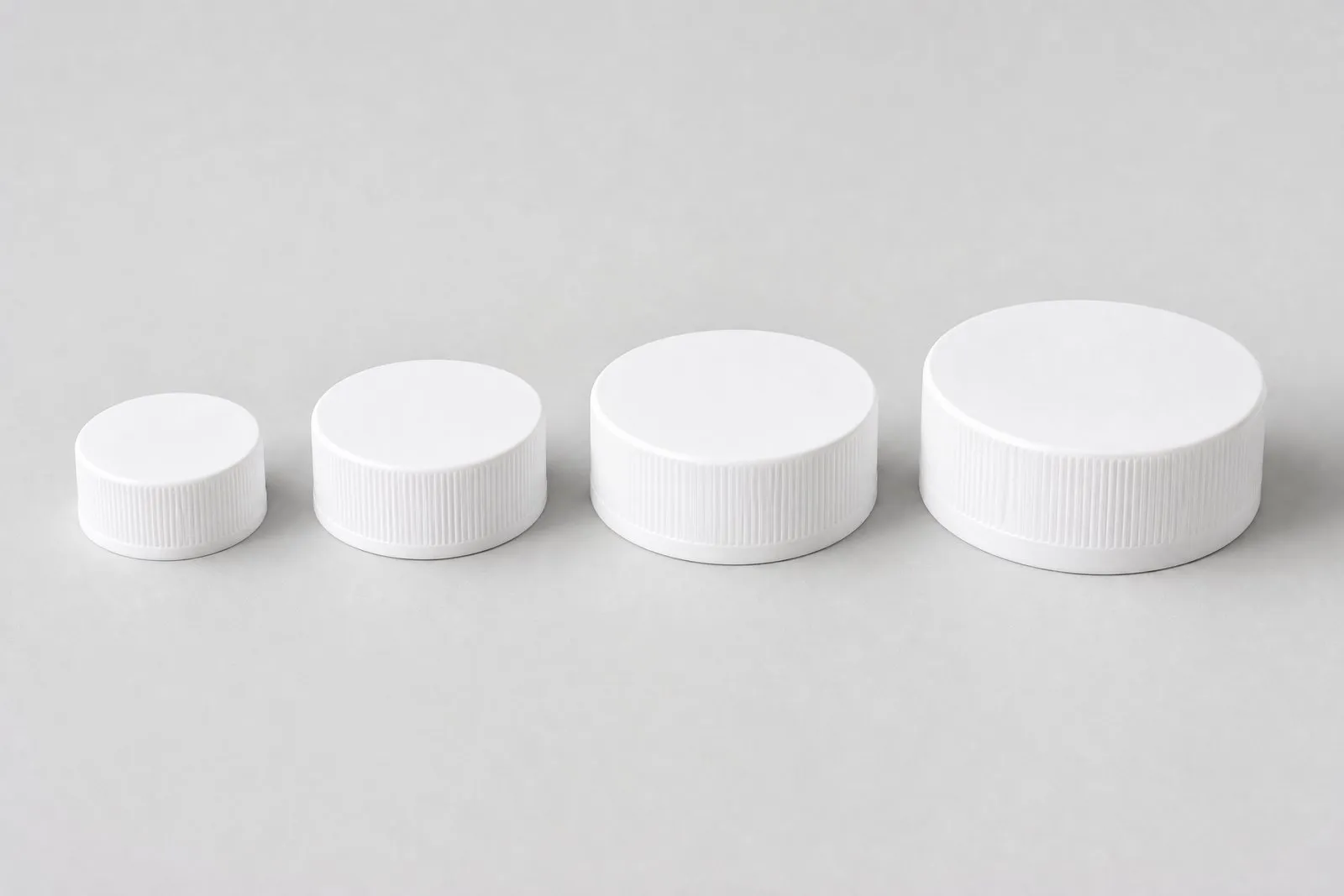 White bottle caps from 33 to 53 mm in ribbed, smooth, flip-top and child-resistant styles