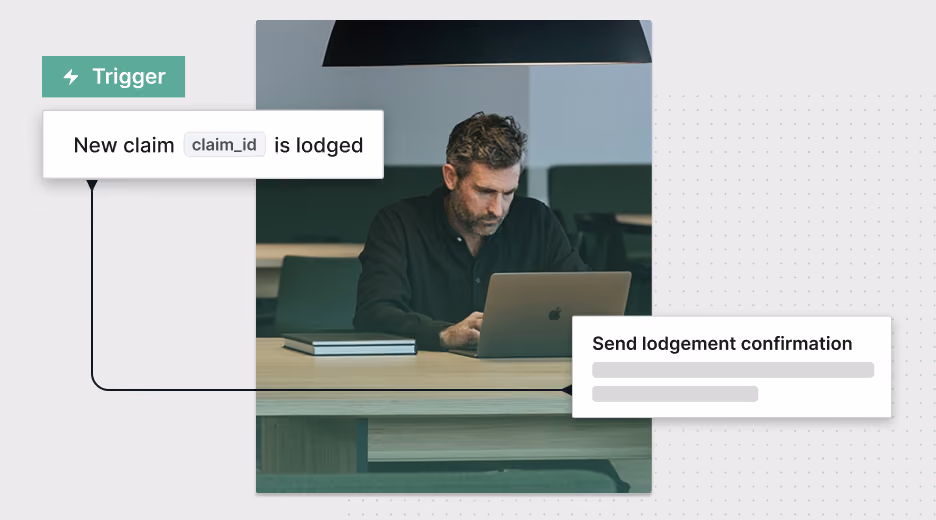 Man using a laptop at a desk with visual labels showing a claim trigger and lodgement confirmation.