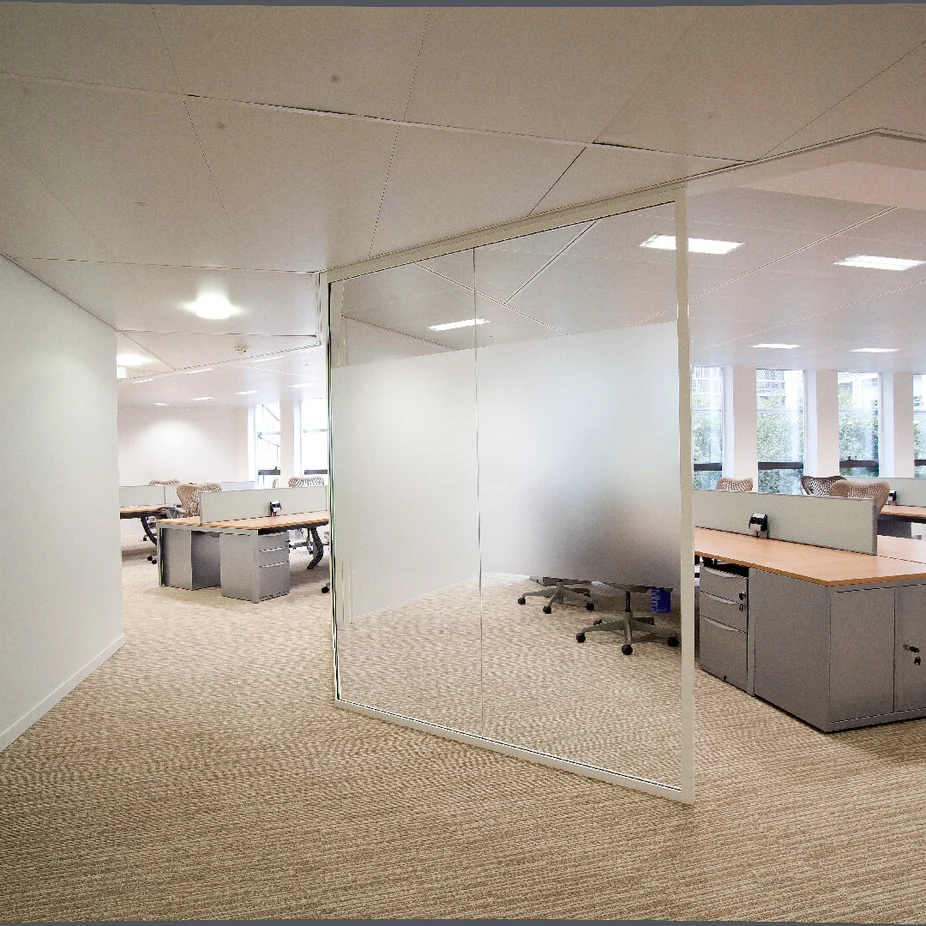 Open-plan office seen through a frosted glass partition