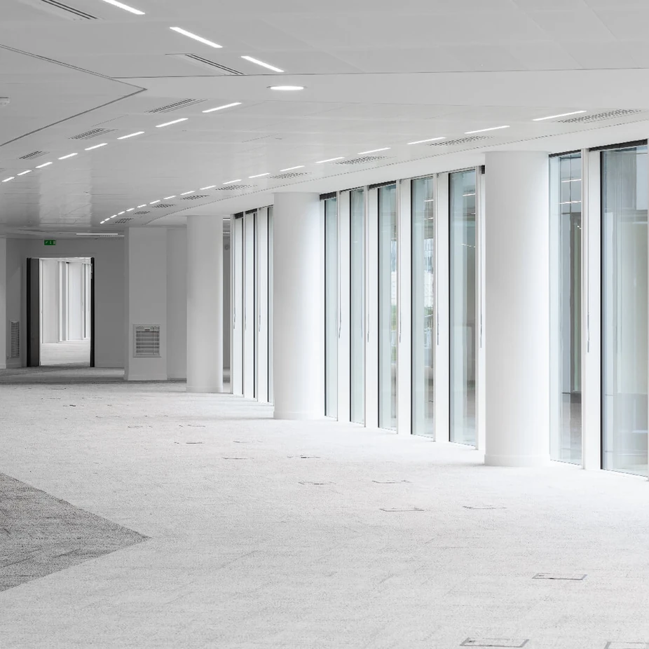 Unfurnished office floor with full-height windows and curved lighting
