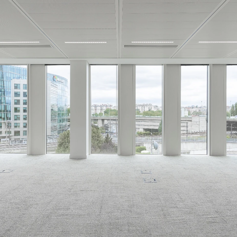 Empty office space with tall windows overlooking the city