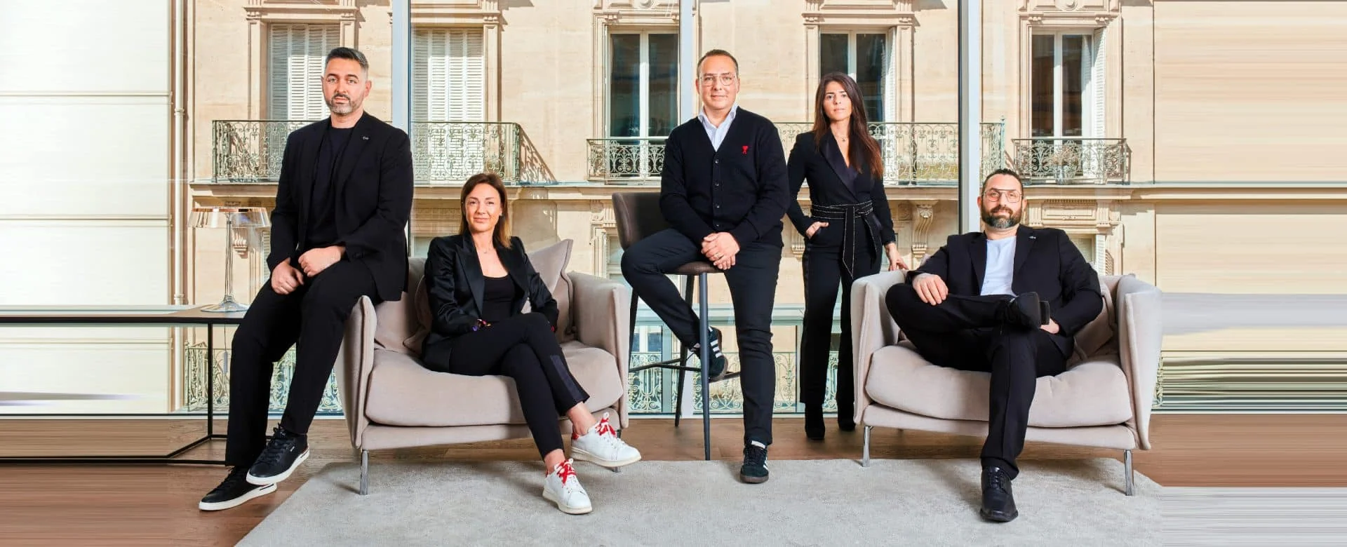 BMA management team of five posing in a bright office lounge with armchairs