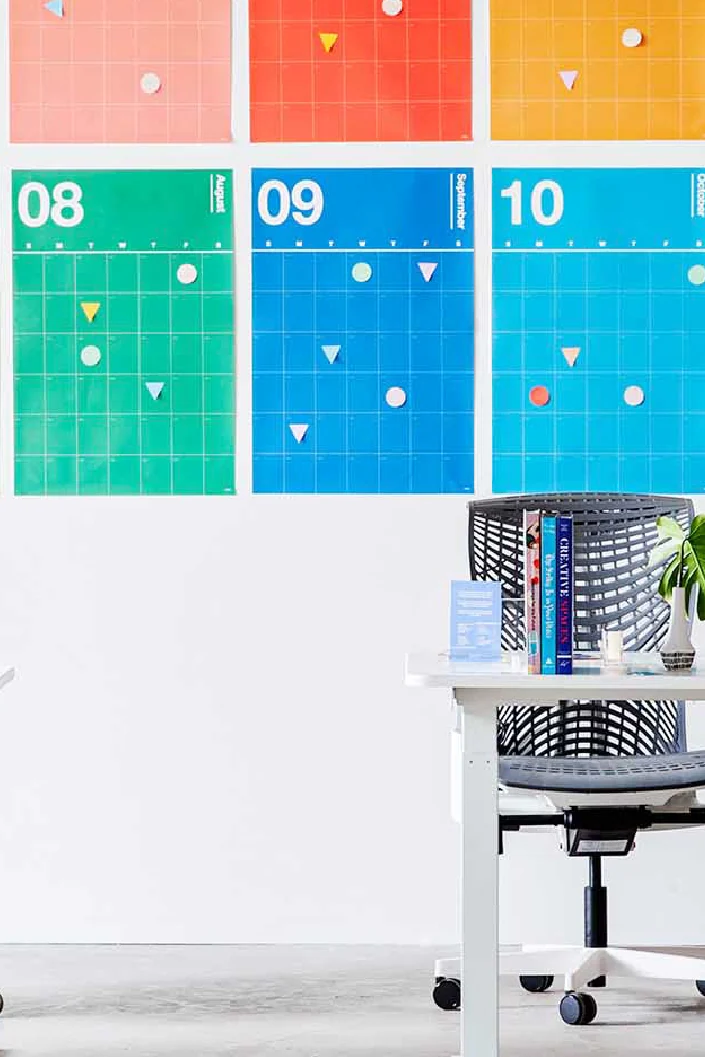 Workstation in front of a colourful wall calendar graphic