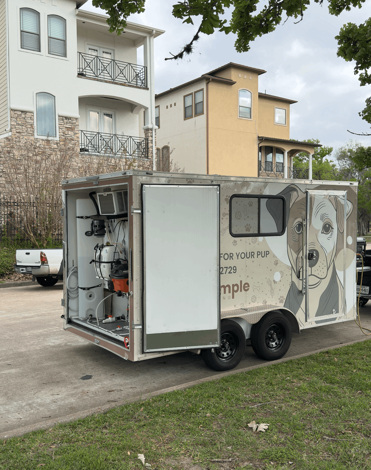 A dog grooming trailer outside a customers house.