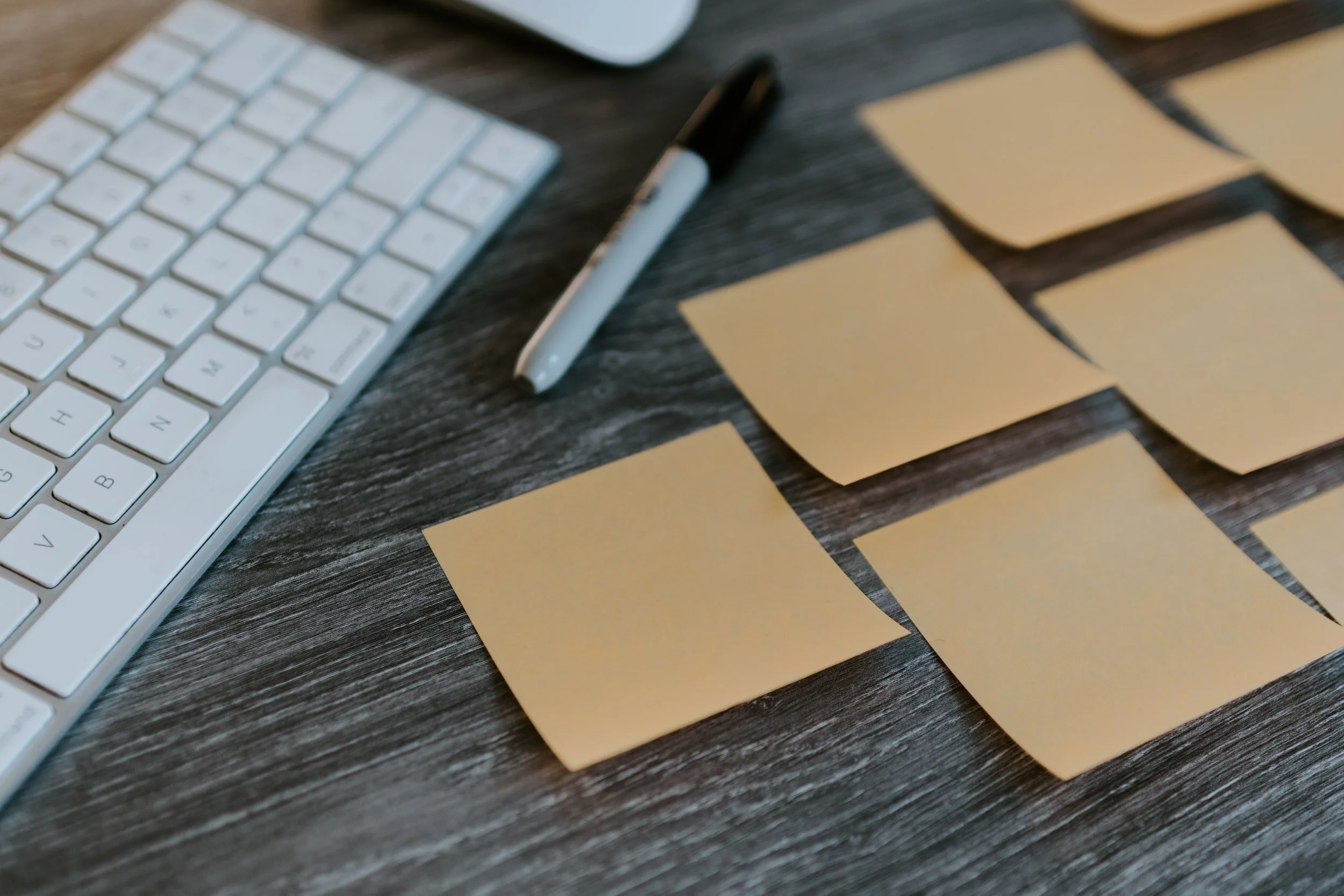 Blank sticky notes arranged on a desk beside a keyboard