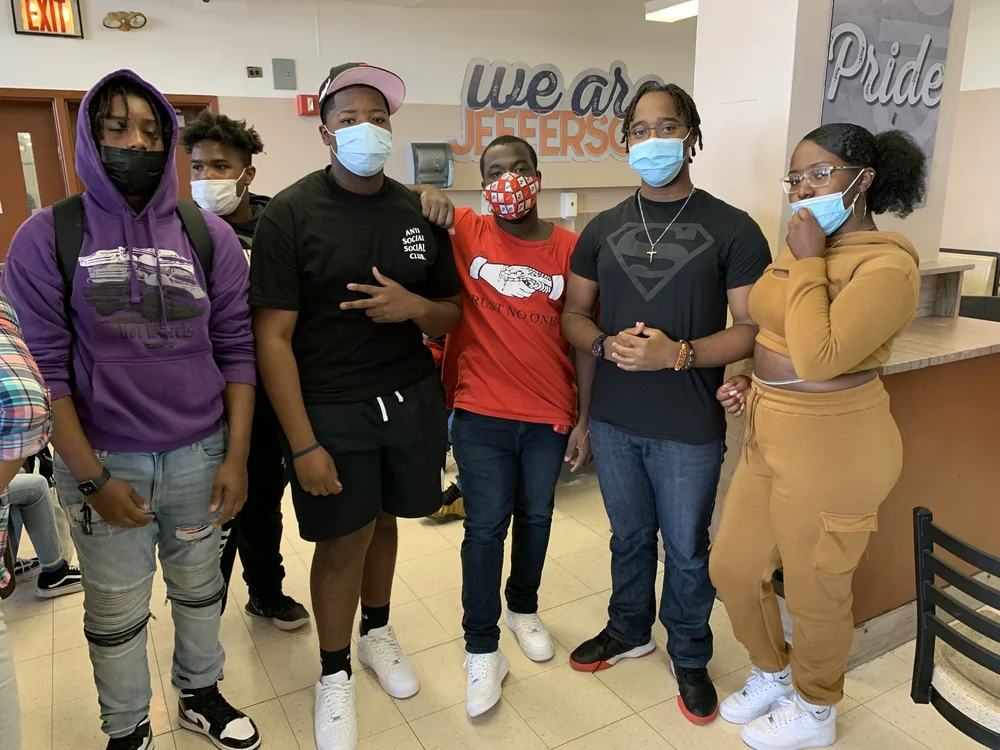 Masked students posing together in Jefferson High School hallway