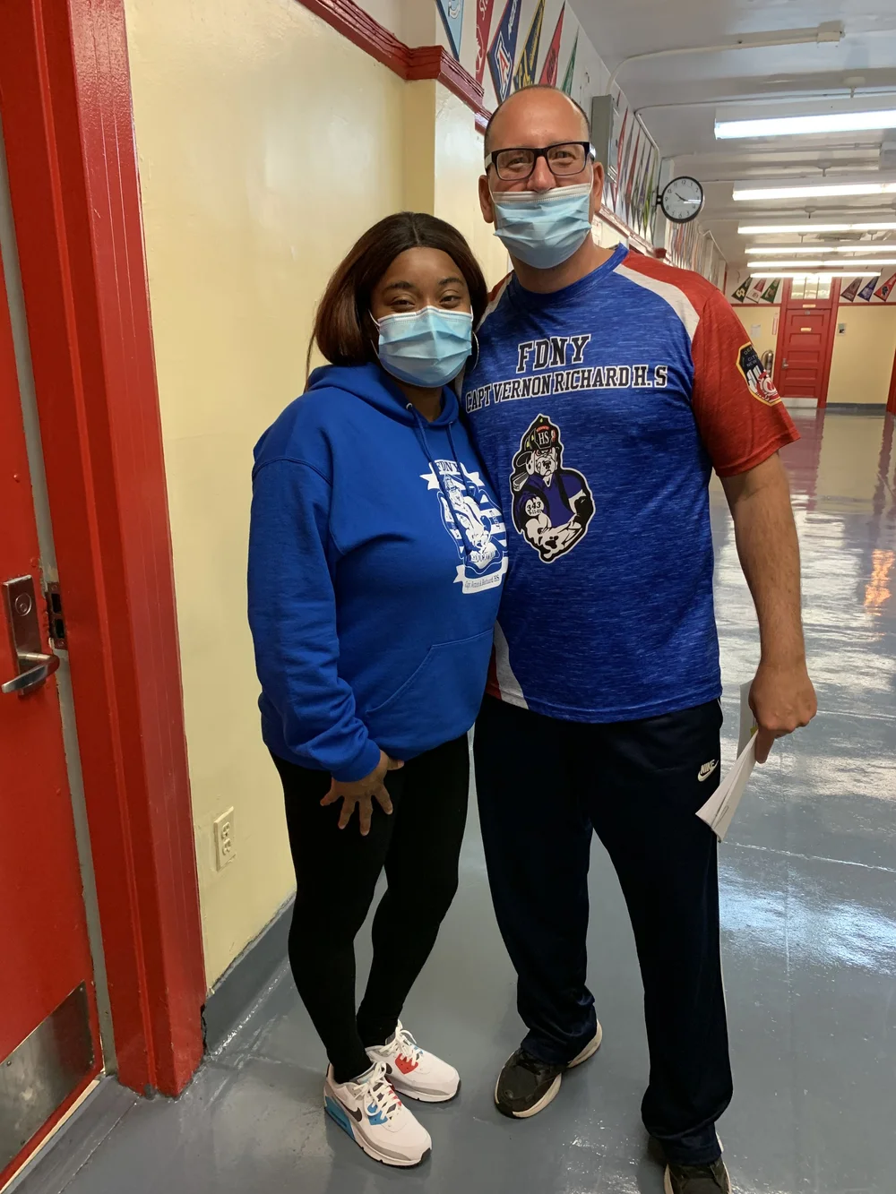 Student and staff member wearing FDNY High School gear in hallway