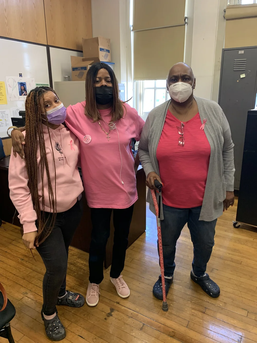 Three staff members wearing pink in support of breast cancer awareness