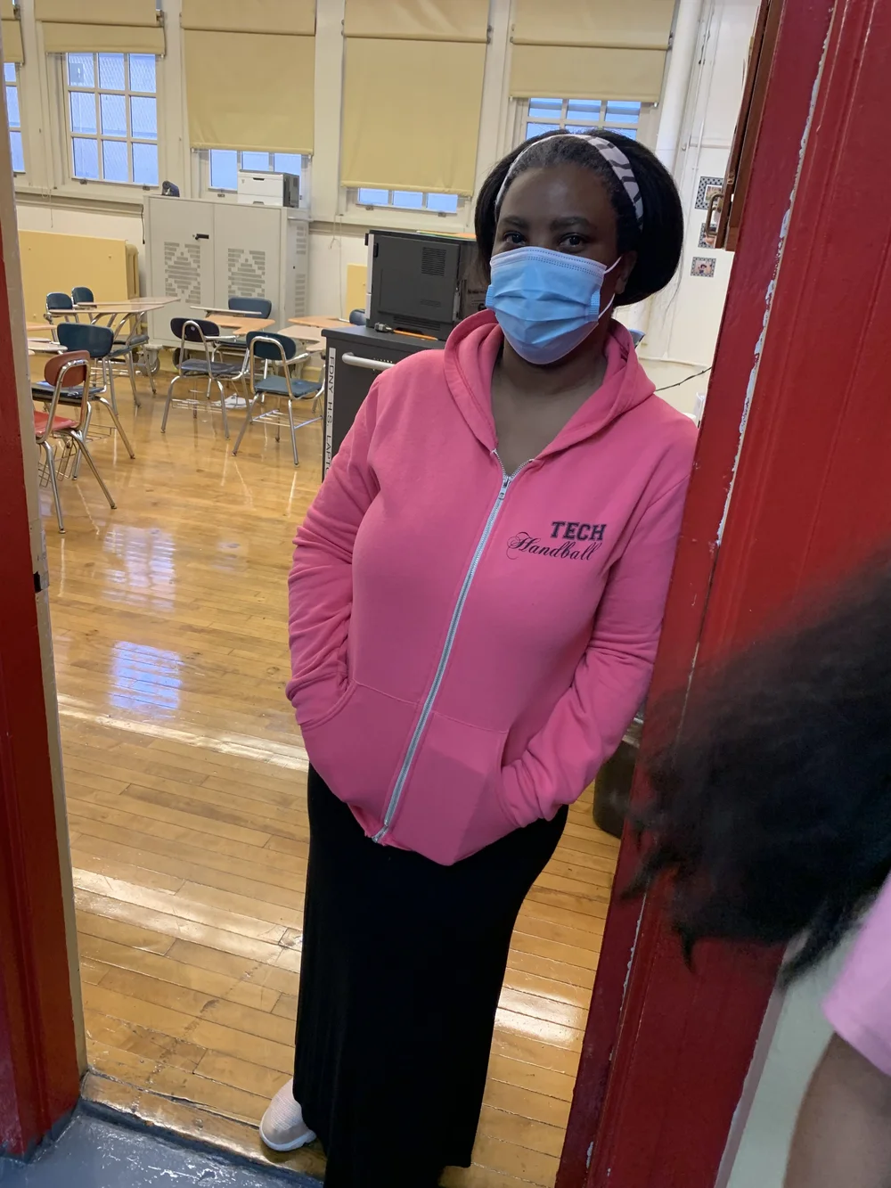 Staff member wearing Tech Handball jacket and mask in school gymnasium