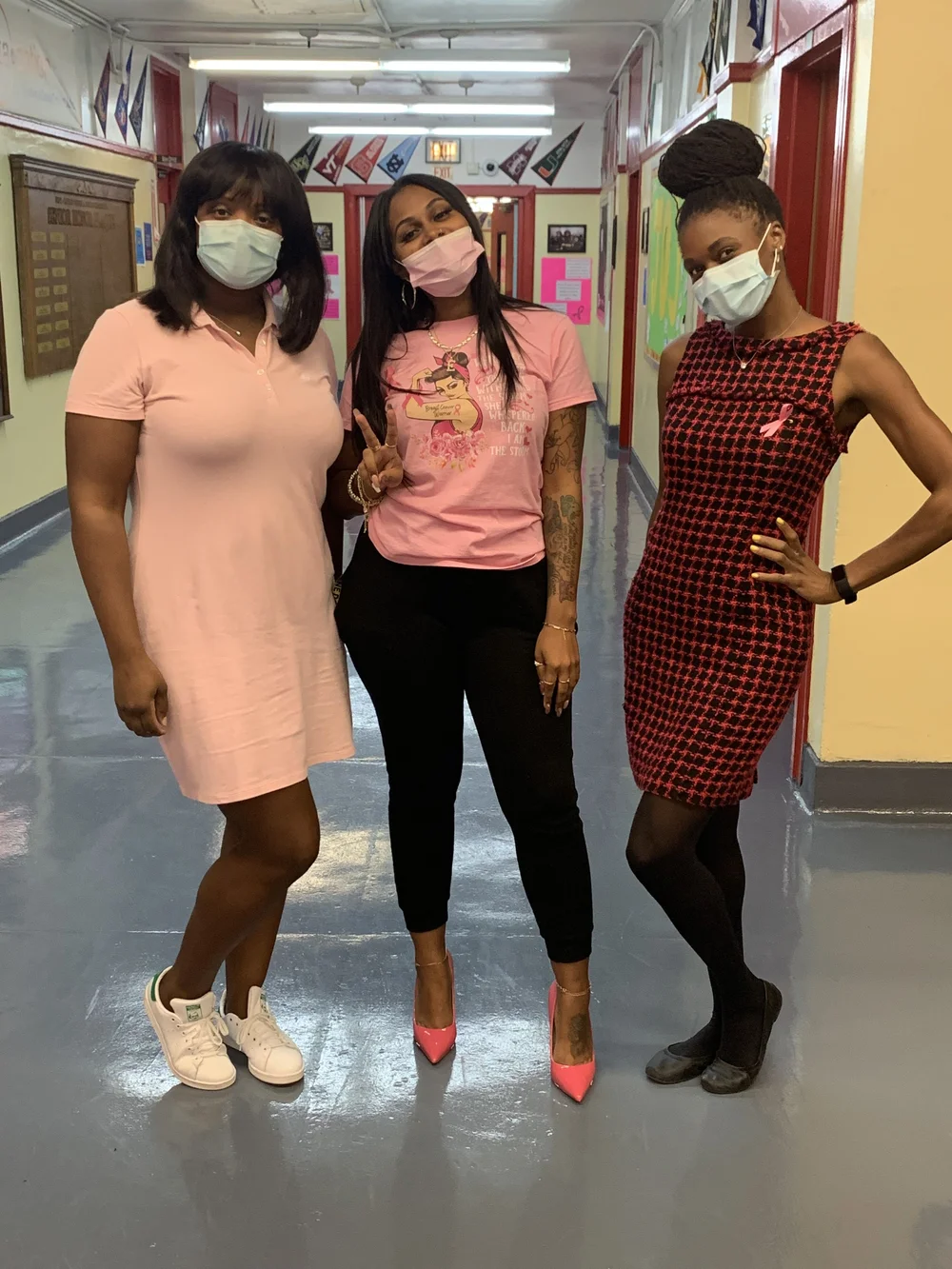 Three masked staff members wearing pink for Breast Cancer Awareness Month
