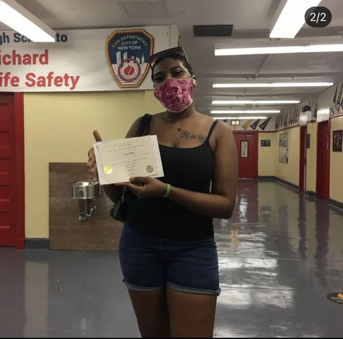 Student holding certificate inside FDNY High School for Life Safety