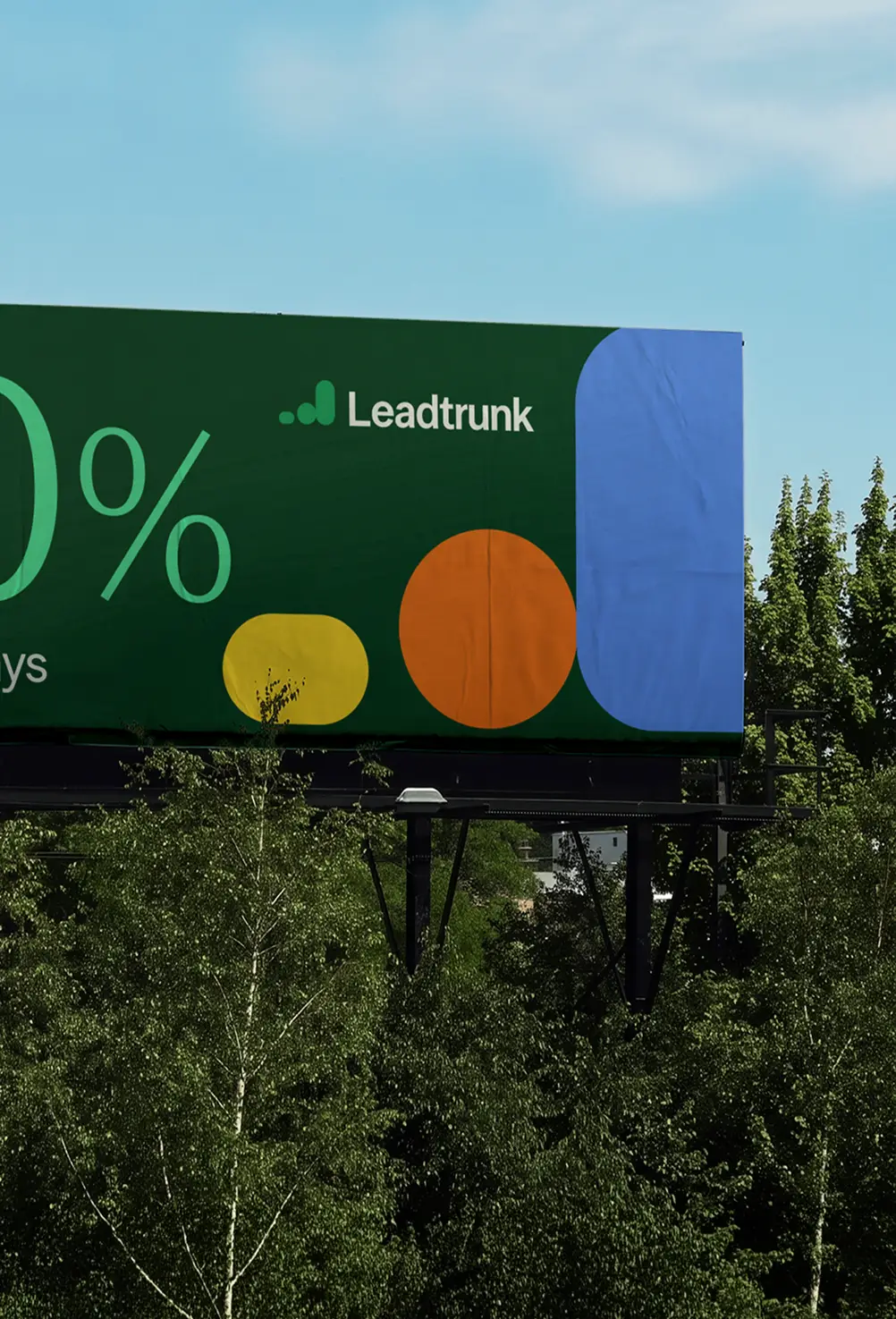 Billboard with Leadtrunk logo and colorful circle shapes above green trees under blue sky.