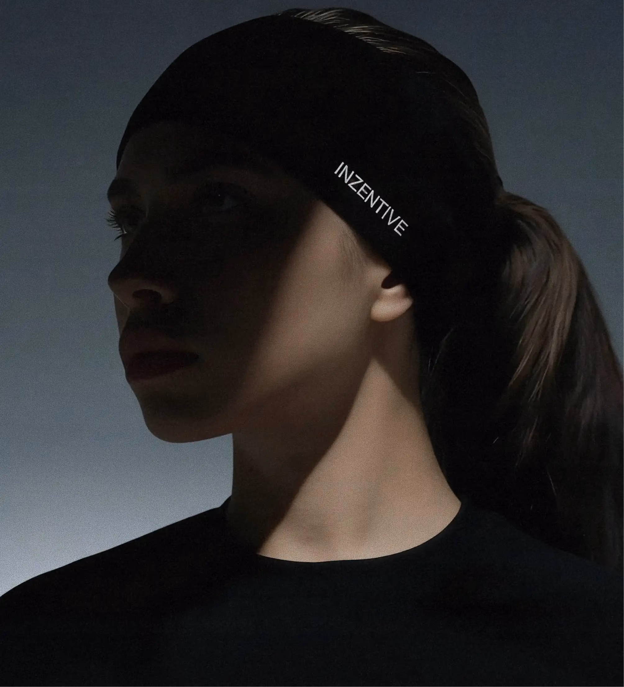 Close-up profile of a woman wearing a black headband with the Inzentive logo.