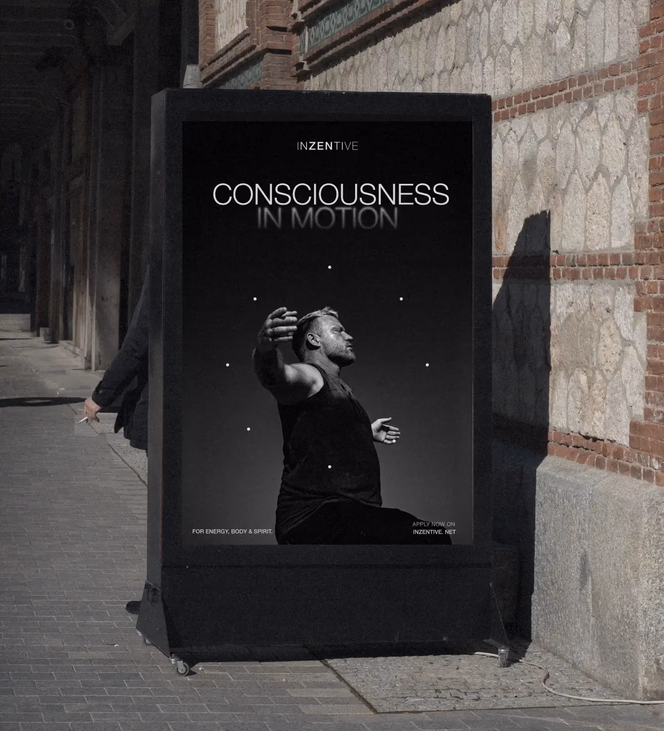 Outdoor ad kiosk displaying "Consciousness in Motion" poster with a man in a dynamic pose.