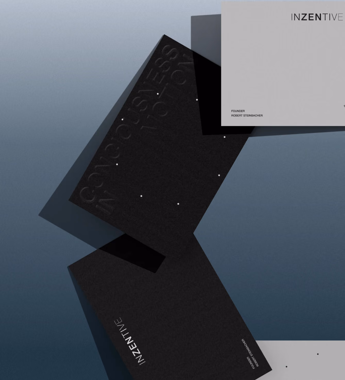 Black embossed business cards with the Inzentive logo, shown at an angle with dramatic lighting.