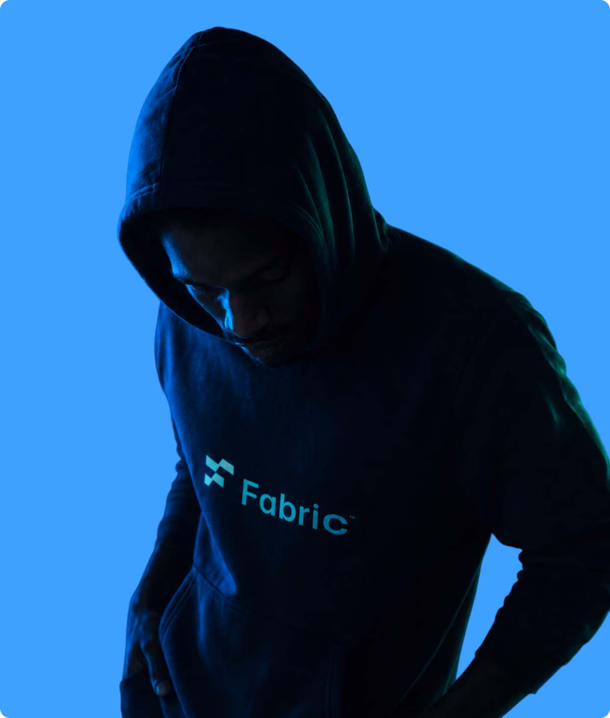 Silhouette of a man in a dark blue Fabric-branded hoodie against a blue background.