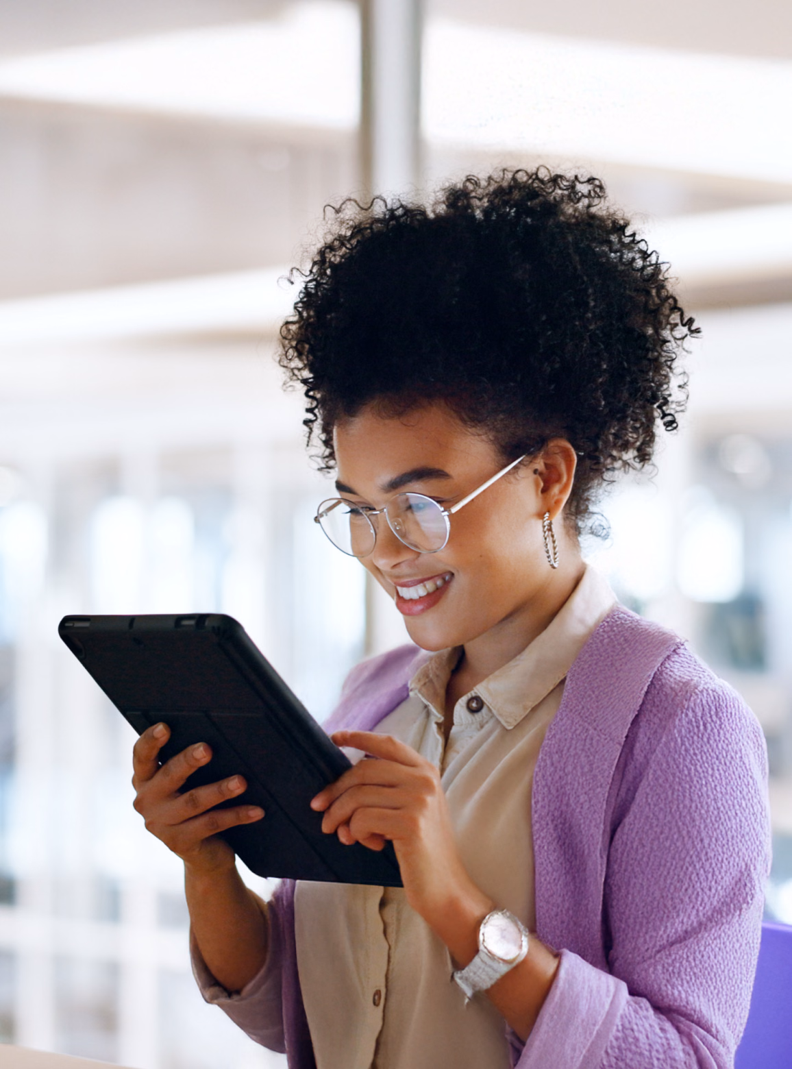 Woman in a lavender jacket using a tablet