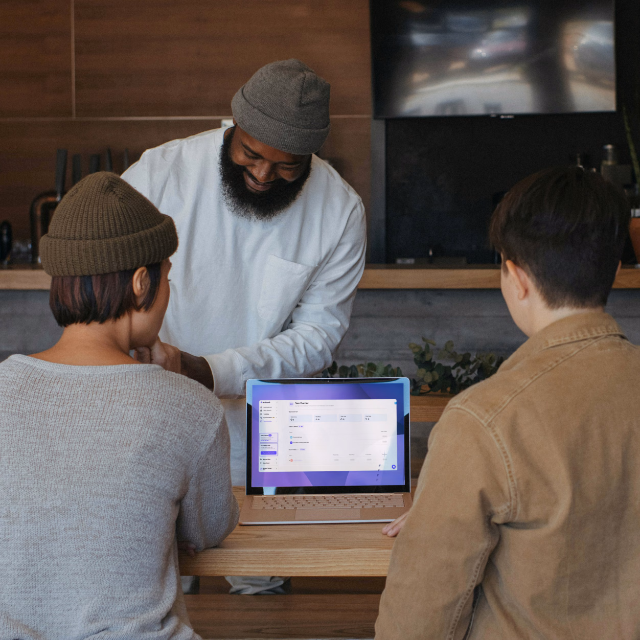 A team collaborating around a laptop running Sendspark.