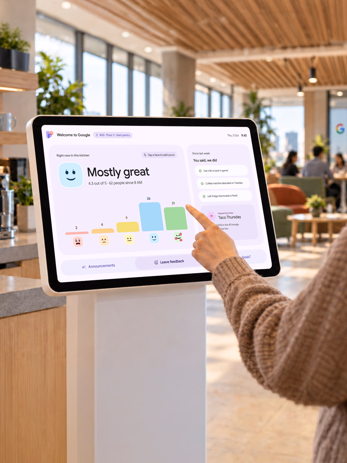 An employee gives feedback at a Google office tablet kiosk.
