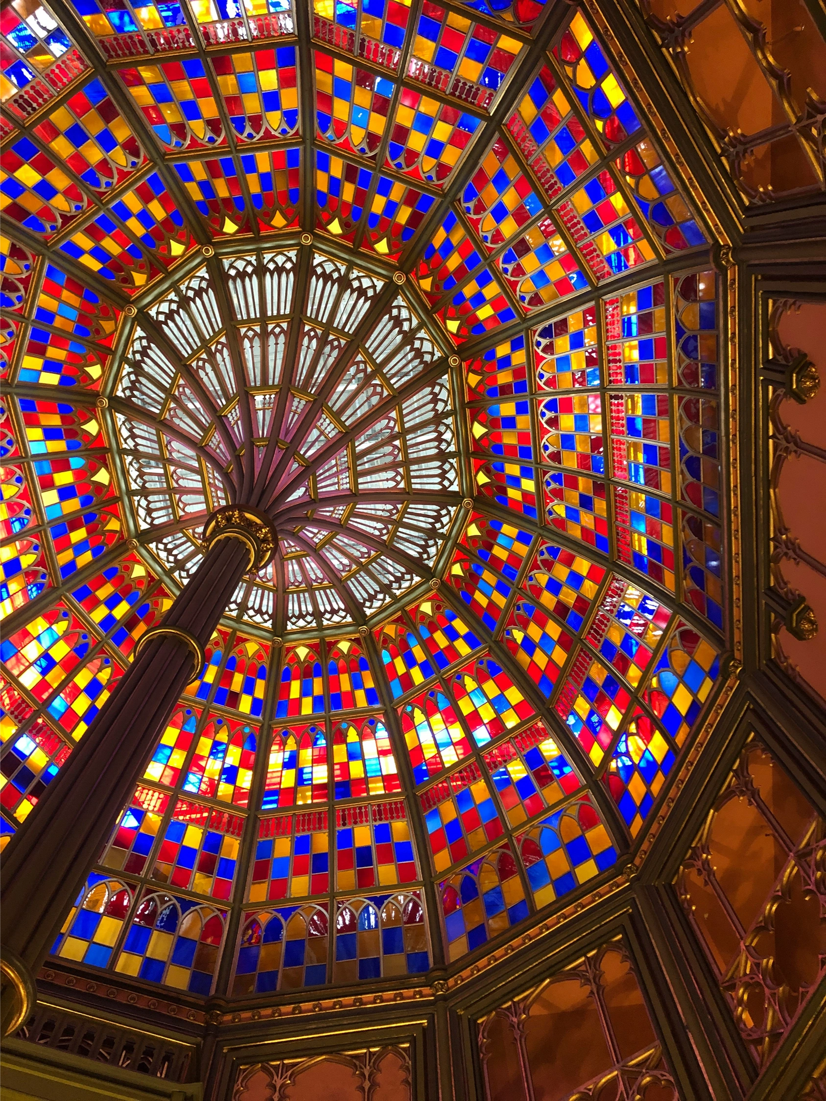Colorful stained-glass ceiling with a circular geometric design.