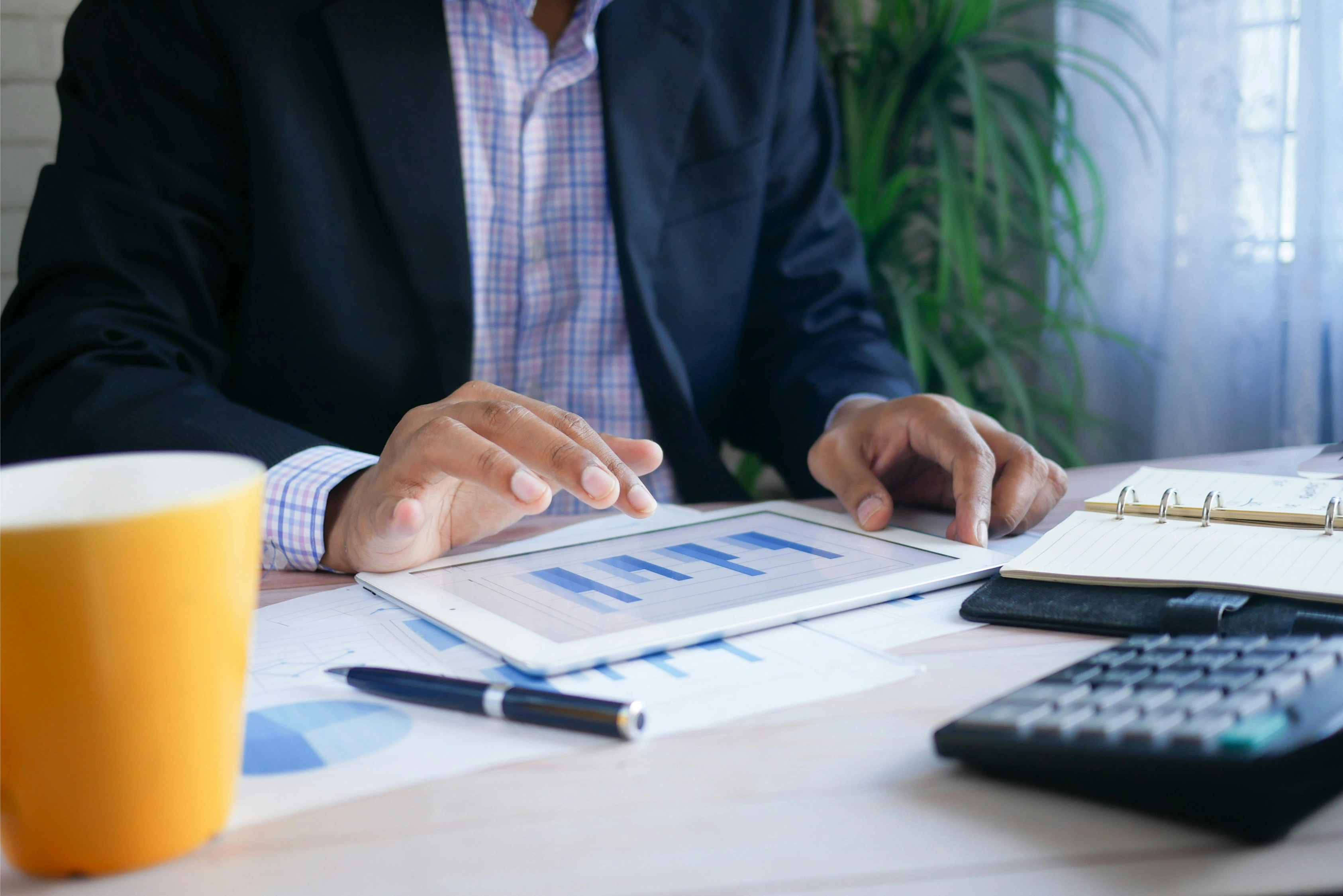 Business professional reviewing financial charts and documents at a desk.